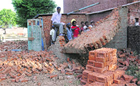 Employees of the enforcement wing of the municipal corporation remove illegal structures in Sector 29 of Chandigarh on Wednesday. 