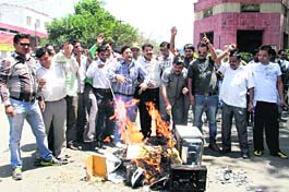 BJP workers burn electrical equipment at Clock Tower to protest against power shortage in Dehradun on Wednesday.