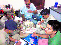The police counts the currency seized from the Taiwanese nationals at Chauntra, Mandi