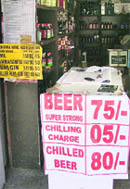 A liquor vend displays the price list of beer. 
