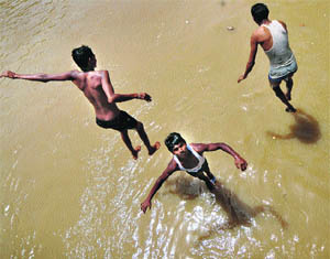 Boys jump in Sidhwan Canal to cool off on a hot day in Ludhiana.