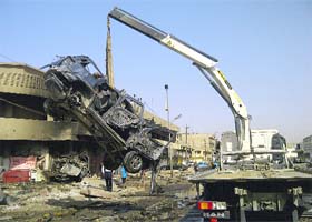 VIOLENCE-STRUCK: A burnt vehicle is removed from the site of a bomb attack in Baghdad on Wednesday