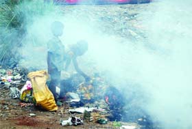 Kids collect scrap from the garbage set on fire in Amritsar