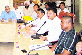 Ashok Tanwar, Sirsa MP, is flanked by J. Ganesan, DC, (left) and Munish Nagpal, SDM, at a meeting in Sirsa
