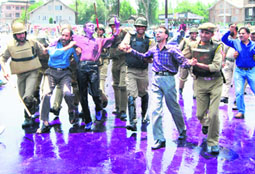 Protesting government employees being restrained by the police in Srinagar