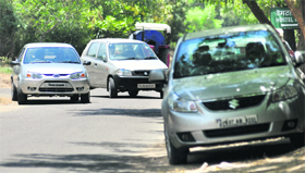 Vehicles parked along a road in the university.