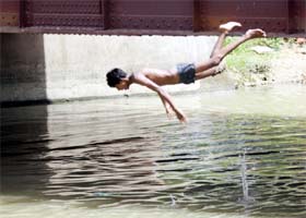 Summer fun Boy jumps into the water on a hot summer day in Amritsar