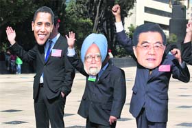 Activists wearing masks of G-20 leaders (L-R) US President Barack Obama, Indian PM Manmohan Singh and Chinese President Hu Jintao wave during a protest for food security at the Monument to the Revolution in Mxico City on Thursday