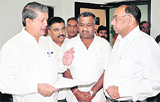 Union Minister of State for Agriculture, Food Processing and Parliamentary Affairs Harish Rawat submits a memorandum to CMD, Uttarakhand Power Corporation, AK Johri (right) in Dehradun on Friday.