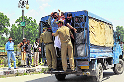The police detains protesting government employees in Srinagar on Friday