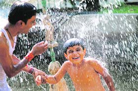 A child enjoys a fountain shower at the Bage Bahu Park in Jammu