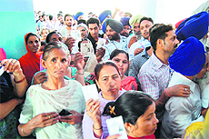 Voters queue up outside a polling booth in Amritsar on Friday.