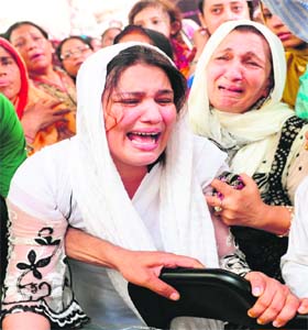 Family members of Mehdi Hassan mourn during his funeral ceremony in Karachi