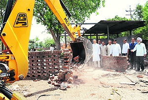 A JCB machine demolishes the Safai Suvidha Centre in Sector 48, Chandigarh, on Saturday.