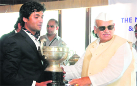 Uttarakhand Governor Aziz Qureshi gives away the winning trophy to Gaurav Sanwal on Saturday.