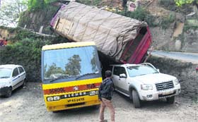 A truck rests precariously on vehicles parked near Tara Hall in Shimla on Sunday