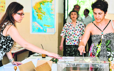 Women cast their vote at a polling station in Athens on Sunday. 
