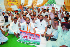 Former Bathinda MLA, Harminder Singh Jassi and other Congress workers, sit on a dharna outside the District Administrative Complex in Bathinda on Monday.