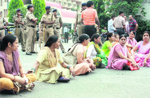 Victims of the candle cottage industry fraud hold a dharna on the Gandhi road against police inaction in Dehradun on Monday. 
