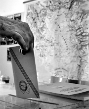 A man casting his ballot before a map of Greece in polling station in Athens on June 17, 2012.