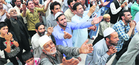 Devotees pray as an unseen custodian displays a holy relic, believed to be a hair from the Prophet Muhammad's beard, at the Hazratbal shrine in Srinagar on Monday.