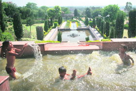 Children enjoy in a fountain at Bage Bahu Park in Jammu on Monday. 