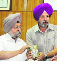 PAU profs, Dr Daljit Singh Khurana and Dr Paramjit Singh Brar, with a can of the saag made from Chinese cabbage