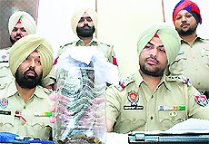 Police officials show weapons seized from robbers in Rajpura on Monday. 