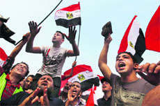 Supporters of Egypts Muslim Brotherhood candidate Mohammed Mursi wave national flags at Tahrir Square in Cairo on Monday.