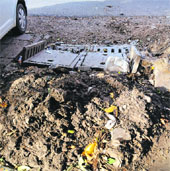 Broken road gullies and garbage lying on a roadside at Sector 20