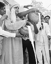 Milkmen pour milk into a drain in Delhi to protest low prices.