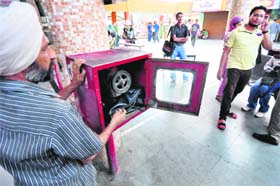 A bus conductor keeps his bag inside firefighting equipment at a bus stand in Ludhiana