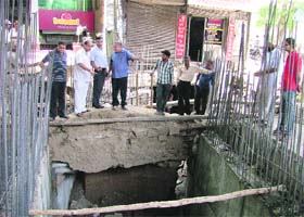 Officials of the municipal corporation inspect the repair work of a road that had caved in near Clock Tower in Ludhiana on Tuesday