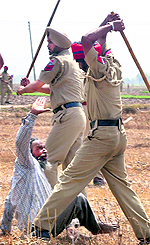Policemen hit a protesting farmer with lathis at Balberha village in Patiala