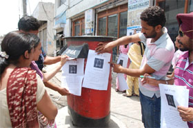 Members of the 7654 Sanjha Front paste Gumshuda Di Talash posters showing the CMs empty chair in Bathinda on Wednesday. 
