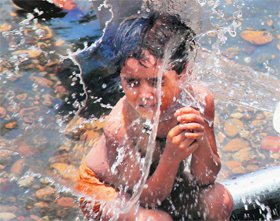 A boy cools himself as mercury soars in Jammu on Wednesday.