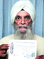 NRI Gurbax Singh Sahota shows his NRI Sabha membership card in Jalandhar on Wednesday