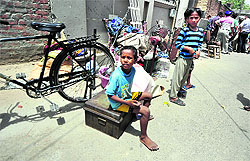 A child sits outside the building, which the municipal officials had gone to demolish at Sunet village in Ludhiana on Wednesday
