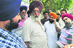 MC officials argue with Harpreet Singh Bedi (in orange turban) where they had gone to get a piece of the land vacated at Sunet village