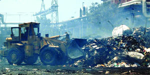 A ditch machine lifts the burnt mateiral at Khanna Paper Mill in Amritsar on Thursday.