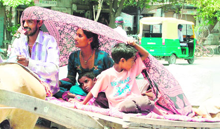 Cover With temperature hovering over 40C, a cart puller and his family cover themselves with a piece of cloth to escape the scorching heat in Amritsar on Thursday. 