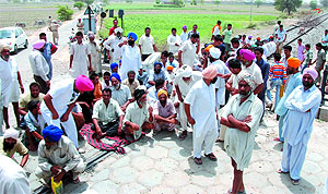 Villagers sit on the Bathinda-Ferozepur track to protest against railway authorities indifference towards unmanned crossings