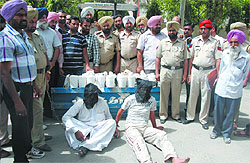 Police personnel with the seized heroin and the two accused