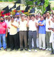 Congress leaders, led by PCC general secretary Ram Kumar Choudhary, show black flags to Health Minister Rajeev Bindal at Landewal village on Thursday. 
