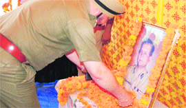 A police officer pays floral tributes to DGP Radha Vinod Raju in Jammu.