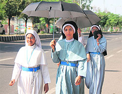 Nuns walk along a road on a hot Thursday afternoon in Jammu