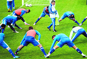 Greeces coach Fernando Santos (C) walks as his players stretch during a training session at the Municipal Stadium in Legionowo. Greece face Germany in the quarterfinals on Friday
