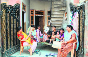 Residents forced to sit outside their houses because of long power cuts in Amritsar on Friday. 