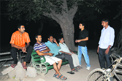Residents sit in the open at night following an unscheduled power cut in Sector 42, Chandigarh, on Friday. Tribune photos: Pradeep Tewari