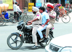 Rules? These policemen seem to be completely oblivious of not only the drive launched by the traffic police in the city to penalise traffic rules violators, but also of the traffic rules. tribune photo: Pawan Sharma